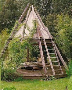 an old wooden structure in the middle of a field with stairs leading up to it