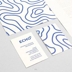 two business cards on top of each other with blue and white lines in the background