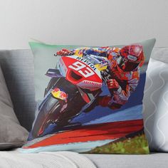 a person riding a motorcycle on a track throw pillow