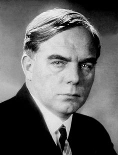 an old photo of a man in a suit and tie looking at the camera with serious expression on his face