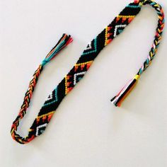 a multicolored bracelet with tassels and beads on a white table top