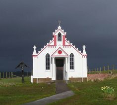 a white and red church with a black sky in the background