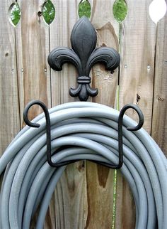 a garden hose holder with a fleur de lis on it