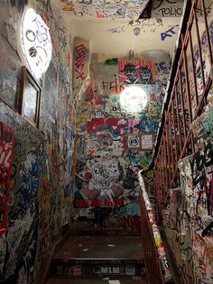 an alleyway with graffiti all over the walls and stairs leading up to it's entrance