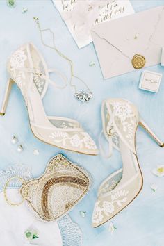 wedding shoes and jewelry laid out on a blue background