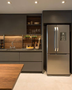 a modern kitchen with stainless steel appliances and wooden counter tops, along with an island in the middle