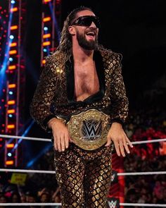 the wwe wrestler is standing in front of an audience wearing sunglasses and a gold suit