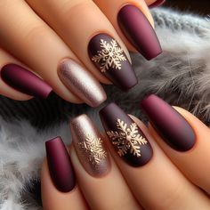 Elegant winter nail art with a matte finish in deep burgundy, adorned with gold snowflake accents Christmas Nail Ideas Short Acrylic, Holiday Burgundy Nails, Christmas Nails Dark Colors, December Nails Burgundy, Burgundy Snowflake Nails, Christmas Elegant Nails Classy, Dark Red Christmas Nails Short, Burgundy And Champagne Nails, Burgundy Winter Nail Designs