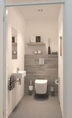 a white toilet sitting inside of a bathroom next to a wall mounted sink and mirror