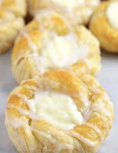 several pastries sitting on top of a table covered in white icing and melted cheese