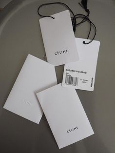 three white tags with the name cline on them sitting on top of a plate