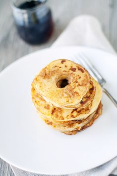 a stack of pancakes sitting on top of a white plate next to a knife and fork