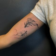 a woman's arm with a feather tattoo on it