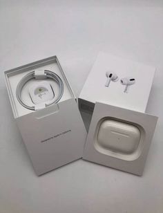 an opened box with earphones inside it on a white surface, next to the packaging