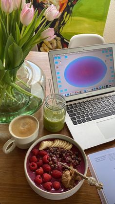 there is a bowl of fruit and yogurt next to a laptop on the table