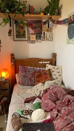 an unmade bed with lots of stuff on top of it in a small room