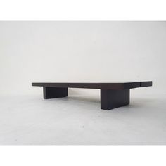 a black coffee table sitting on top of a white floor next to a gray wall