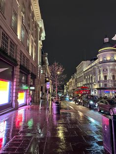 a city street at night with cars parked on the side walk