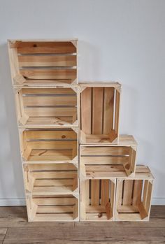 a stack of wooden crates sitting on top of a hard wood floor next to a wall