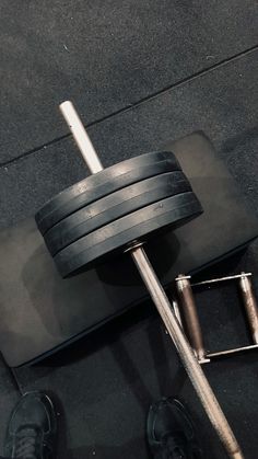 a man standing next to a barbell on top of a floor