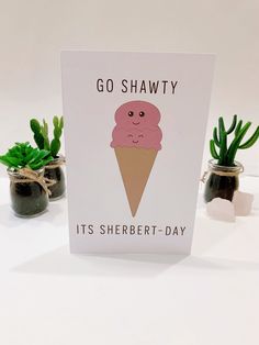 a card with an ice cream cone on it and succulents in the background