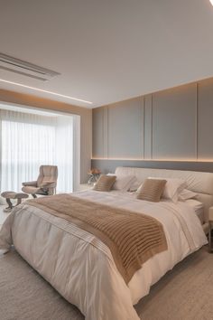 a large white bed sitting in a bedroom next to a window