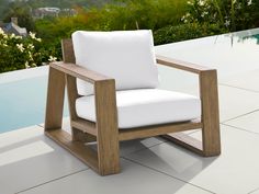 a white chair sitting on top of a tiled floor next to a pool