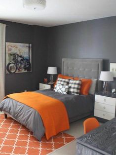 a bedroom with gray walls and orange accents