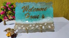 a welcome home sign sitting on top of a table next to a figurine