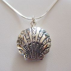 Locket Details: This shell locket is made of genuine 925 Sterling Silver Stamped 925 Holds two photos Includes 18" 925 Sterling Silver snake chain with spring ring clasp Measurements: 25mm x 22mm x 8mm (1" x 7/8" x 5/16") Arrives in a gift box Shipping Details: All orders are shipped within 1 business day (excluding US Holidays) All orders are shipped from Texas, USA International Buyers: Please see Shipping & Payments tab regarding Customs Fees Return Details: Risk-Free 30-Day Return Policy Customer Service: 9am to 4pm CST Monday-Friday (excluding US Holidays) Please message us with any questions! Vintage Pendant Necklace For Beach, Silver Engraved Necklace For Beach, Elegant Silver Necklace For Beach, Silver Shell Jewelry With Lobster Clasp, Silver Shell-shaped Jewelry With Lobster Clasp, Necklaces Wire, Seashell Locket, Silver Earrings Outfit, Shell Locket