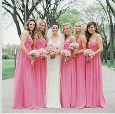 a group of women in long dresses standing next to each other with bouquets on their laps