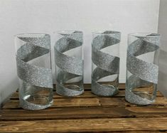 three glass vases with silver glitter ribbons on them