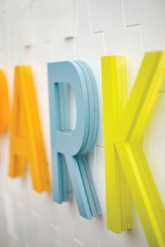 the word park spelled with colored letters on a white wall in front of a white background