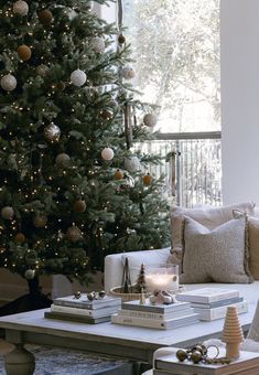 a living room with a christmas tree in the corner and presents on the coffee table