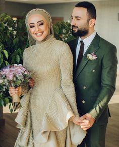 a man and woman dressed in formal wear standing next to each other holding bouquets