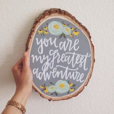 a person holding up a sign that says you are my greatest adventure on the wood