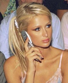 a woman talking on a cell phone while sitting in front of other people at a party