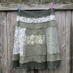 a skirt hanging on a clothes line with two birds perched on the clothes line next to it