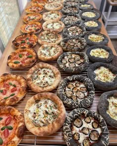 many different types of pizzas on a table