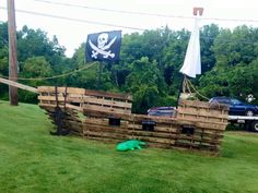 a pirate ship made out of pallets in the grass