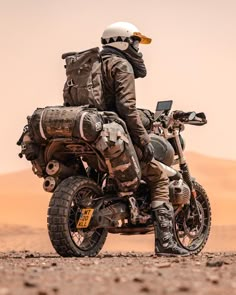 a man riding on the back of a dirt bike in the middle of the desert