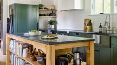 a kitchen filled with lots of green cabinets and counter top next to a stove top oven