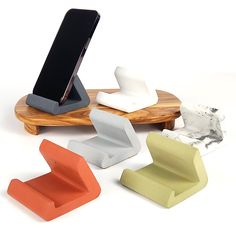 an assortment of cell phone holders on a wooden stand, with one charging device in the middle