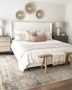 a white bed sitting in a bedroom on top of a rug