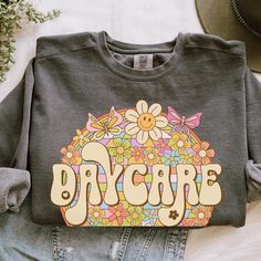 Celebrate the amazing daycare provider in your life with this charming Daycare Provider Gift! Show your gratitude and appreciation with this thoughtful Daycare Teacher Appreciation Gift. This cozy Daycare Sweatshirt is perfect for keeping warm and comfortable throughout long days of caring for little ones. Made with high-quality materials, this sweatshirt features a stylish design that proudly honors the dedication and hard work of daycare providers. Whether it's for a special occasion or just b Daycare Worker Outfit Ideas, Gift For Daycare Provider, Daycare Teacher Appreciation, Daycare Outfits, Daycare Provider Gifts, Daycare Providers, Daycare Teacher, Teacher Appreciation Gift, Heartfelt Gifts