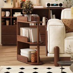 a living room filled with furniture and a book shelf next to a white couch on top of a hard wood floor