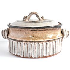 a brown and white pot with handles on it's side, sitting on a table