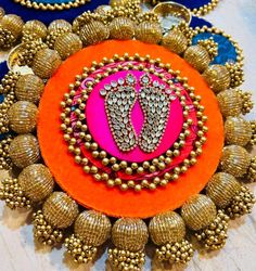 an orange and pink brooch with two pairs of shoes on it