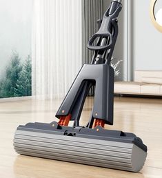 a vacuum mop on the floor in front of a window