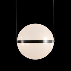 a round light hanging from a black ceiling